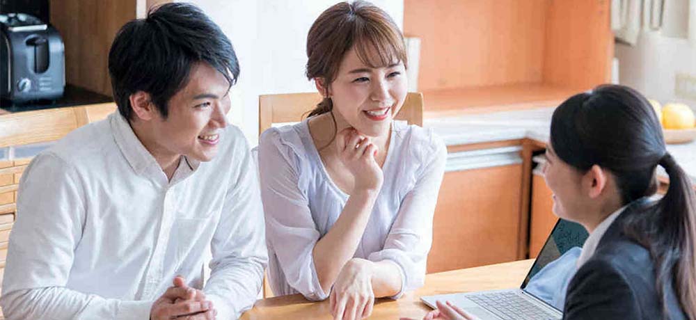 保険訪問営業の女性と話す夫婦の写真